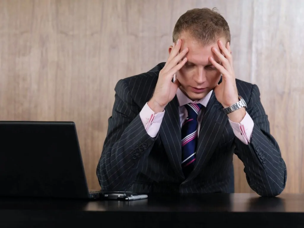 Business man head in hands in office