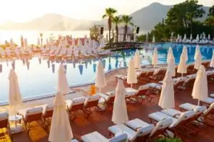 Pool with lounge chairs in resort hotel with mountain view